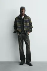 Sobrecamisa de corte relajado confeccionada en tejido con textura efecto pelo. Presenta diseño de cuadros en tonos verde y negro, cuello solapa, cierre frontal con botones, manga larga con puños abotonados y un bolsillo de plastrón en el pecho.