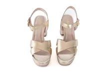 Sandalias de tacón alto color oro claro, con capellada de cuero metalizado, tiras cruzadas en la parte delantera, plataforma y tira ajustable con hebilla al tobillo.