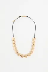 Collar dorado con dijes en forma de corazón, unidos por una cadena fina y un cordón negro.