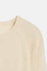 Jersey básico de punto color beige con cuello redondo y manga larga, con acabados en rib.
