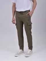 Pantalón tipo jogging cargo color verde militar, con cintura elástica y cordón de ajuste, bolsillos laterales con solapa y puños elásticos en los tobillos.