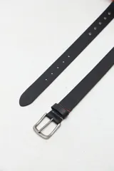 Cinto de cuero negro con tachas metálicas y hebilla de metal empavonado.