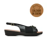 Sandalia casual de cuero negro Usaflex modelo Bernie, diseñada especialmente para juanetes con material elástico frontal, tira ajustable al talón con hebilla dorada y taco bajo.