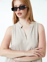 Vestido blanco con escote en V, cuello camisero y corte asimétrico.