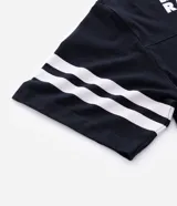 Remera deportiva de corte oversized, color negro, con estampado gráfico en la espalda del equipo Las Vegas Raiders de la NFL. Presenta cuello redondo, mangas cortas con detalles de rayas blancas y logo de la NFL en la parte superior trasera.
