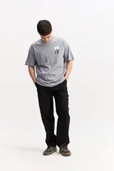 Remera oversize gris de algodón, de manga corta, con estampa en la espalda de formas botánicas abstractas y el logo de la marca.