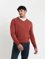 Sweater de punto con escote en V y manga larga, con puños y ruedo acanalados.