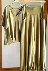 Conjunto de dos piezas color verde oliva, compuesto por una remera de manga corta con escote en V y un pantalón babucha de tiro alto con puños elastizados y bolsillos laterales.