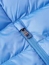 Campera acolchada Tommy Hilfiger color celeste, con capucha extraíble, cierre frontal y bolsillos laterales con cremallera. Logo de la marca bordado en el pecho.