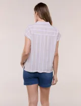 Camisa de lino de estructura recta, color beige con rayas verticales blancas. Cuenta con cuello solapa, escote en V abierto, abotonadura frontal, bolsillo plaqué en el pecho, mangas cortas de hombro caído y ruedo recto.