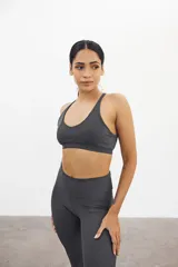 Top deportivo gris con textura acanalada, breteles finos y espalda deportiva.