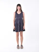Vestido corto gris oscuro sin mangas, con escote redondo, cierre frontal de botones y diseño escalonado en la falda.