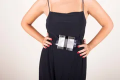 Cinturón blanco con textura símil cuero de cocodrilo y hebilla doble rectangular con apliques de nácar y borde metálico.