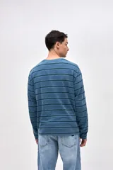Remera de manga larga con diseño de rayas horizontales en tonos azules. Confeccionada en algodón lavado con textura suave y corte clásico.