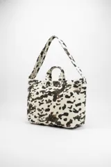 Bolso tipo tote bag con estampado de cebra en tonos beige y blanco, con doble asa de mano y correa larga para el hombro.