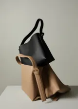 Bolso shopper color beige con asa ajustable y hebillas decorativas.