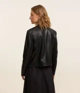 Campera biker color crema confeccionada en cuero sintético, con cuello solapa, cierre frontal con cremallera, bolsillos laterales y mangas largas con detalle de punto roma.