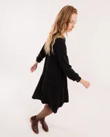 Vestido corto marrón con cuello camisero, abotonado en el frente, mangas largas con elástico en los puños y falda escalonada con volados.