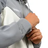 Campera deportiva con capucha y cierre frontal, diseño bicolor en gris y negro con logo de la marca en el pecho y bolsillos laterales con cierre.