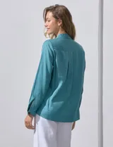 Camisa color verde oliva de lyocell, marca Cyrus. Tiene cuello con solapa, abertura central con botones, mangas 3/4 regulables con presilla y botón, y dos bolsillos delanteros aplicados.