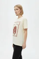 Remera marrón de manga corta y cuello redondo, de corte holgado, con estampado frontal alusivo a frutos del mar y texto "fruits de mer".