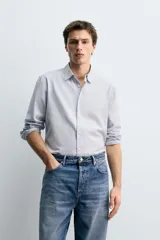 Camisa de corte regular fit confeccionada en una mezcla de algodón y lana. Presenta cuello solapa, manga larga con puños abotonados y cierre frontal con botonadura.