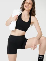 Top deportivo negro de sujeción media con espalda cruzada, confeccionado con tecnología Aloe Vera para una textura suave y elástica.