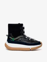 Bota de caña media color negro, con cordones y suela track color caramelo.