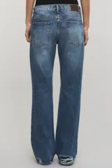 Jeans bootcut de tiro medio color azul, confeccionados en 100% algodón sin elasticidad, con sutiles roturas localizadas y diseño de pernera ensanchada desde la rodilla.