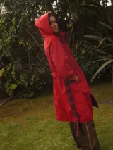 Trench coat impermeable de corte recto en color rojo, reversible con interior de viyela a cuadros, capucha desmontable y lazo para ajustar en la cintura.