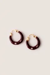Aros tipo argolla gruesa con esmalte color bordó, detalles dorados y una piedra brillante incrustada.