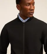 Campera negra de poliéster con cuello mediano, cierre por cremallera, manga larga con ajustes y bolsillos. Cuenta con tecnología repelente al agua.