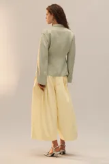 Zapato de tacón con cuerpo cubierto de lentejuelas plateadas, diseño con tira en T, cierre de hebilla en el tobillo y acabado en punta.