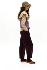 Camisa de popelina de algodón color mostaza con estampado floral blanco. Presenta un cuello amplio con terminación ondulada y encaje de algodón crudo, mangas largas y botones de nácar en el frente.