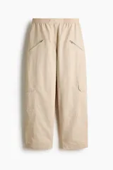 Pantalón cargo de nylon de corte oversized con leve efecto arrugado, cintura elástica fruncida, bolsillos con cierre en el frente y bolsillos con solapa en las piernas.