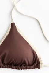 Top de bikini triangular color marrón con ribetes marfil fruncidos, tiras para atar en cuello y espalda, y copas con relleno extraíble.