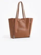 Cartera tipo shopper de cuero vacuno flor graneado, con formato amplio y estructura flexible. Presenta dos cierres verticales decorativos en el frente con tiracierres personalizados y doble manija de hombro.