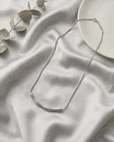 Collar de acero en tono plateado mate, compuesto por una cadena fina y una barra central con diseño curvo y minimalista.