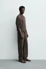 Pantalón cargo straight fit de algodón color negro con efecto lavado, bolsillos laterales en las piernas y cierre frontal con cremallera y botón.