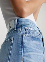 Pantalón de jean celeste con roturas en ambas piernas, de corte mom y tiro alto. Confeccionado con 79% algodón y 21% algodón reciclado.