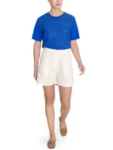Short tipo bermuda de tiro alto confeccionado en lino orgánico. Presenta pinzas frontales, cierre con botón, bolsillos laterales tipo cargo con solapa y botones, y un diseño de estilo outdoor.