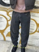 Pantalón de jean negro de corte ancho, con la parte inferior más ancha que la superior.