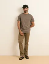 Remera básica de algodón color beige, de manga corta, con cuello redondo y un pequeño detalle bordado en el pecho.