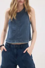 Top de jean blanco sin mangas, con escote redondo, espalda deportiva, costuras pespunteadas en el frente y ruedo desmechado.