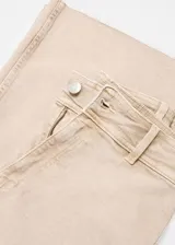 Pantalón jeans estilo culotte de tiro alto, color beige, con trabillas, cierre de cremallera y botón, bolsillos delanteros y traseros, y bajo deshilachado.