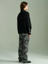 Camisa negra de algodón con mangas largas, cuello camisero y detalles de ribetes estampados a cuadros en los hombros, puños y aberturas de botones.