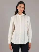 Camisa de popelín de algodón color blanco con finas rayas verticales negras, de corte regular, manga larga, cuello en punta, cierre de botones y bajo redondeado.