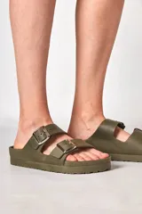 Sandalia tipo Birkenstock de goma color dorado, con doble tira ajustable con hebillas metálicas y suela anatómica.