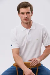 Remera polo lisa de piqué en color bordó, con cuello camisero, cierre frontal con botones y mangas cortas.