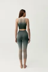Calza deportiva corta de diseño seamless, con efecto degradado que transiciona del gris azulado en la parte superior al marrón en las piernas.